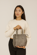 Bolso gris pequeño de piel genuina de res con asas y correa ajustable